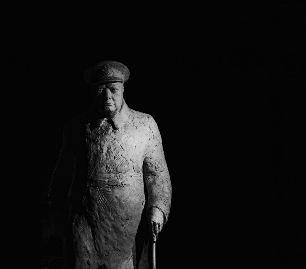 Statue of Winston Churchill Standing against a Dark Background
