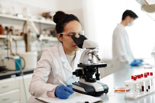 researcher looking through microscope