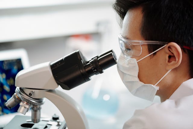 researcher looking through microscope