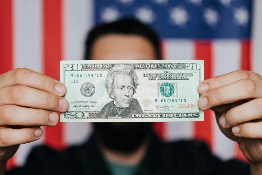 Unrecognizable man showing 20 American dollars
