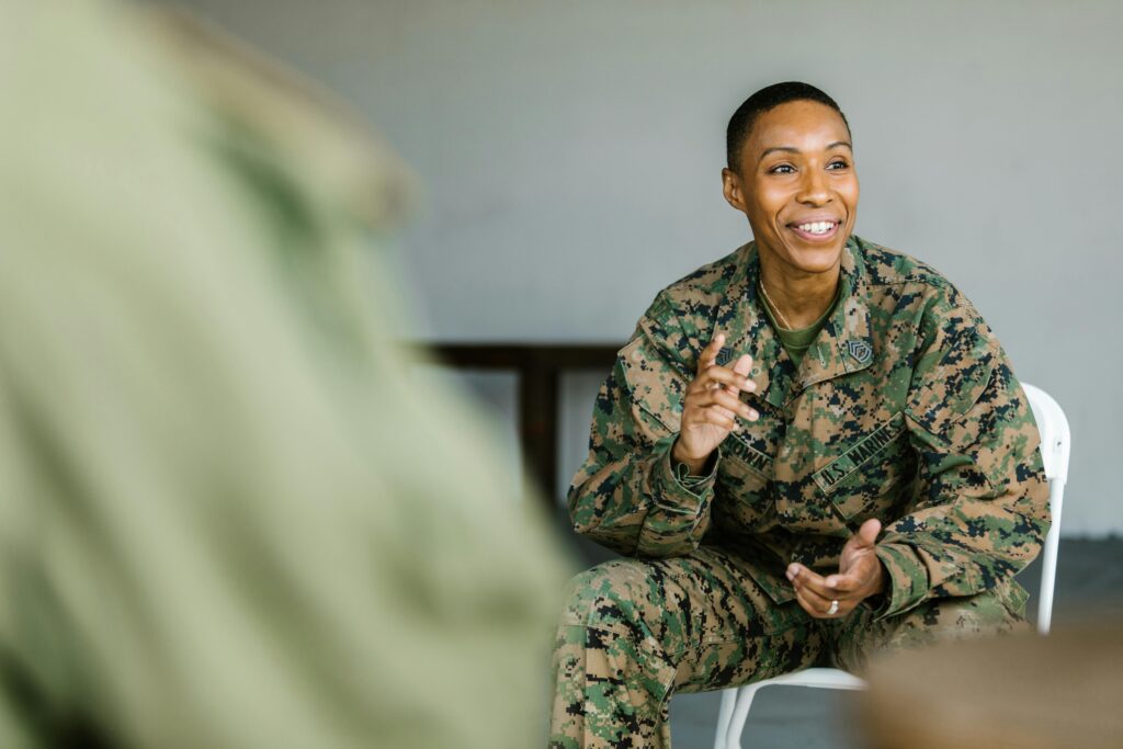 Man in Green and Brown Camouflage Uniform Sitting on White Chair
