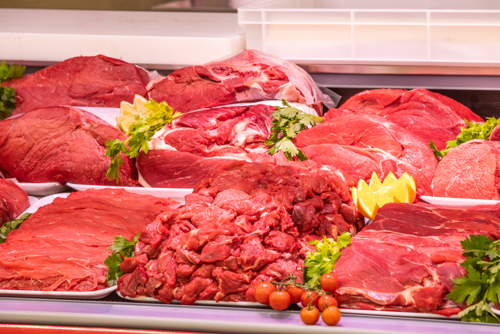Meat department, showcase with variety of meat in different cuts. Inside an Italian supermarket. Different types of fresh meat arranged in an orderly manner.