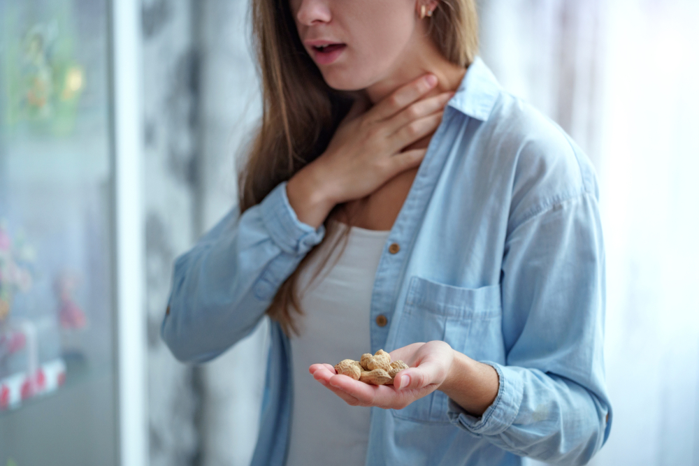 Young woman suffers from choking and cough from peanut allergy. Danger of food allergy 