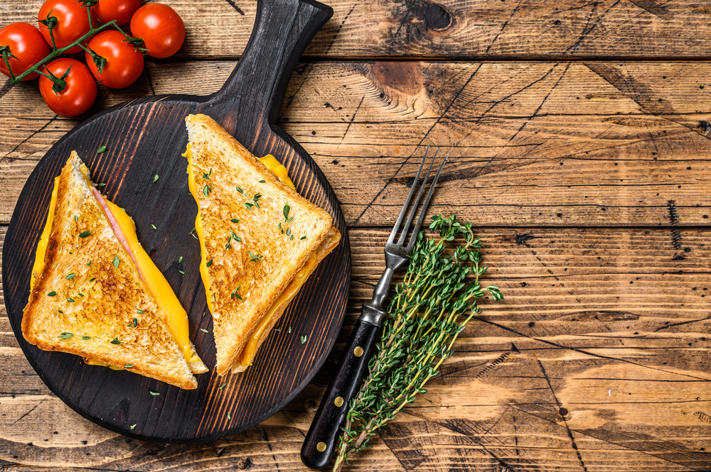 American ham and melted cheese sandwich. wooden background. Top view. Copy space
