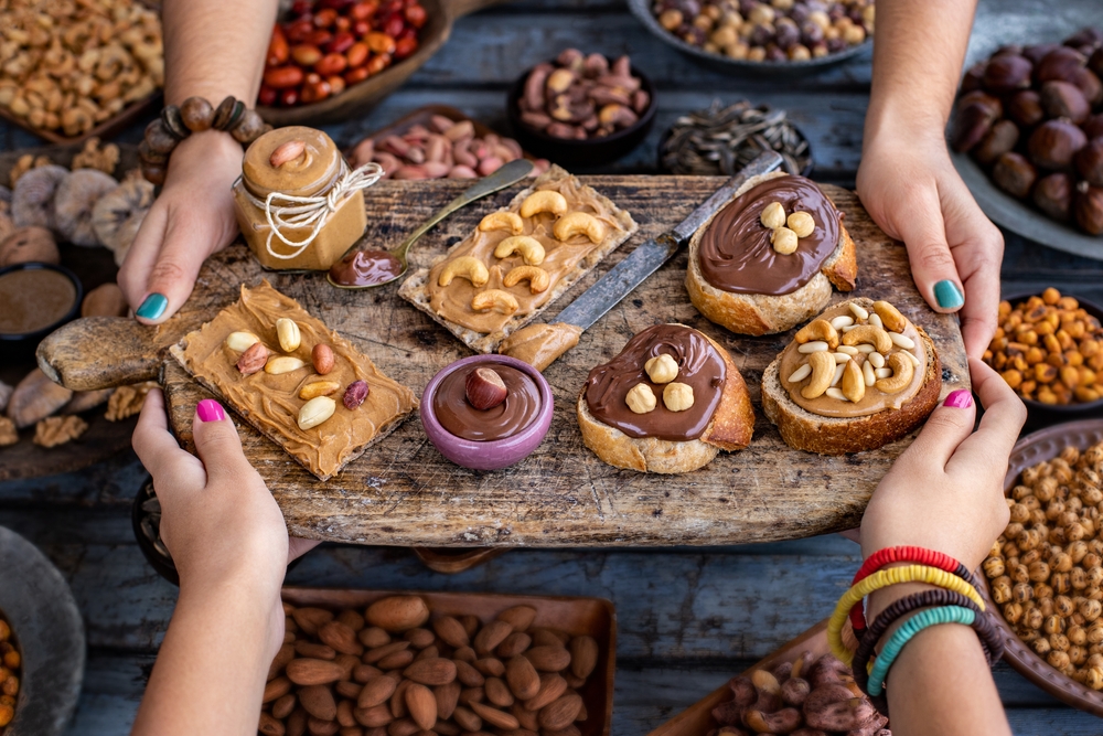 Chocolate hazelnut spread and peanut butter on the bread. Serving and sharing foo with table top view. 