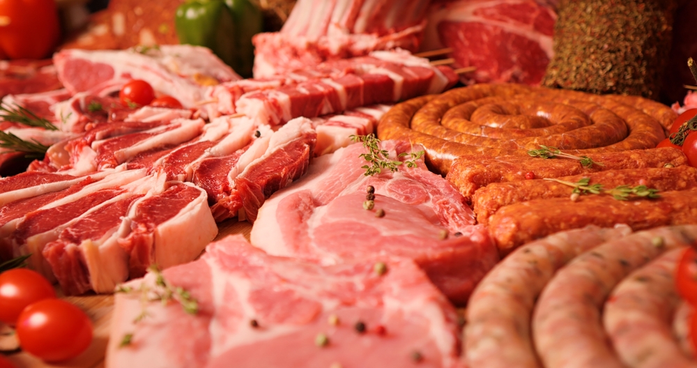 Close-up of raw meat lamb and pork cuts on the table in meat industry. Butchered beef meat ready for restaurant cooks.