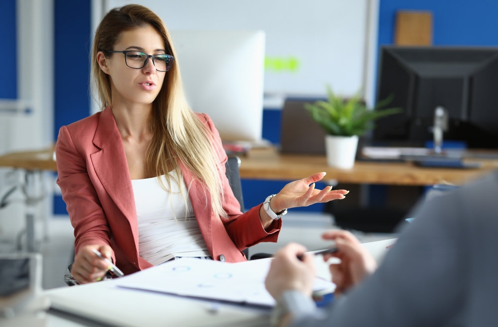 Businesswoman in office communicates with colleague at work.