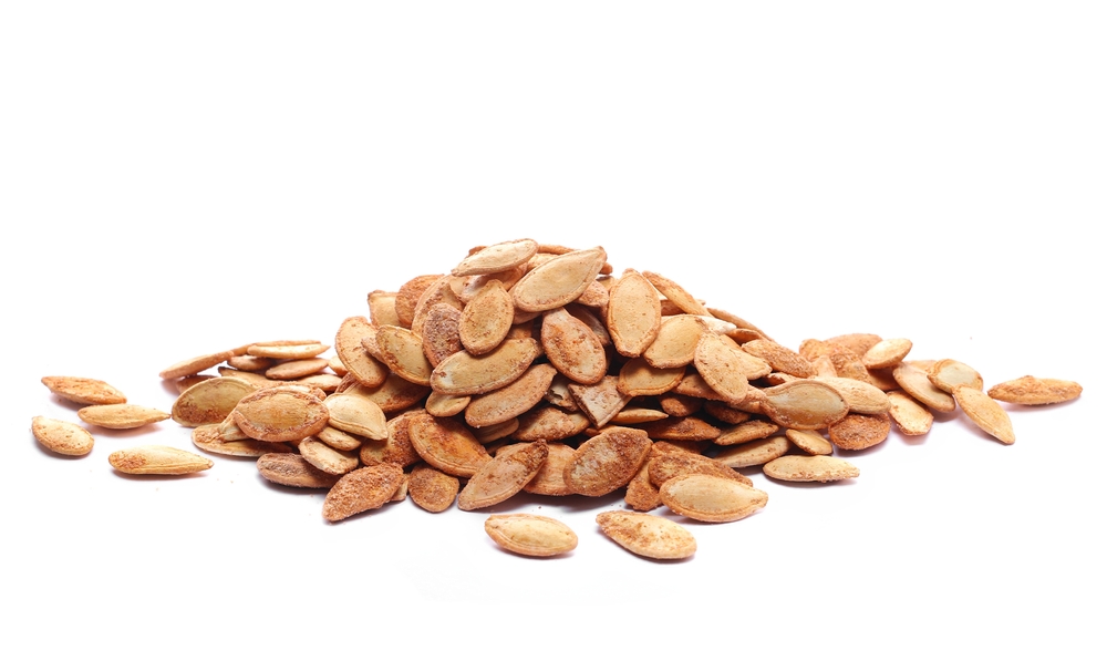 Pile roasted pumpkin seeds with salt isolated on white