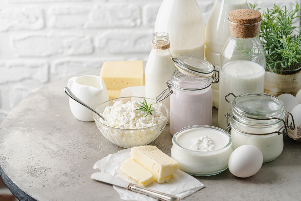 Fresh dairy products, milk, cottage cheese, eggs, yogurt, sour cream and butter on kitchen table