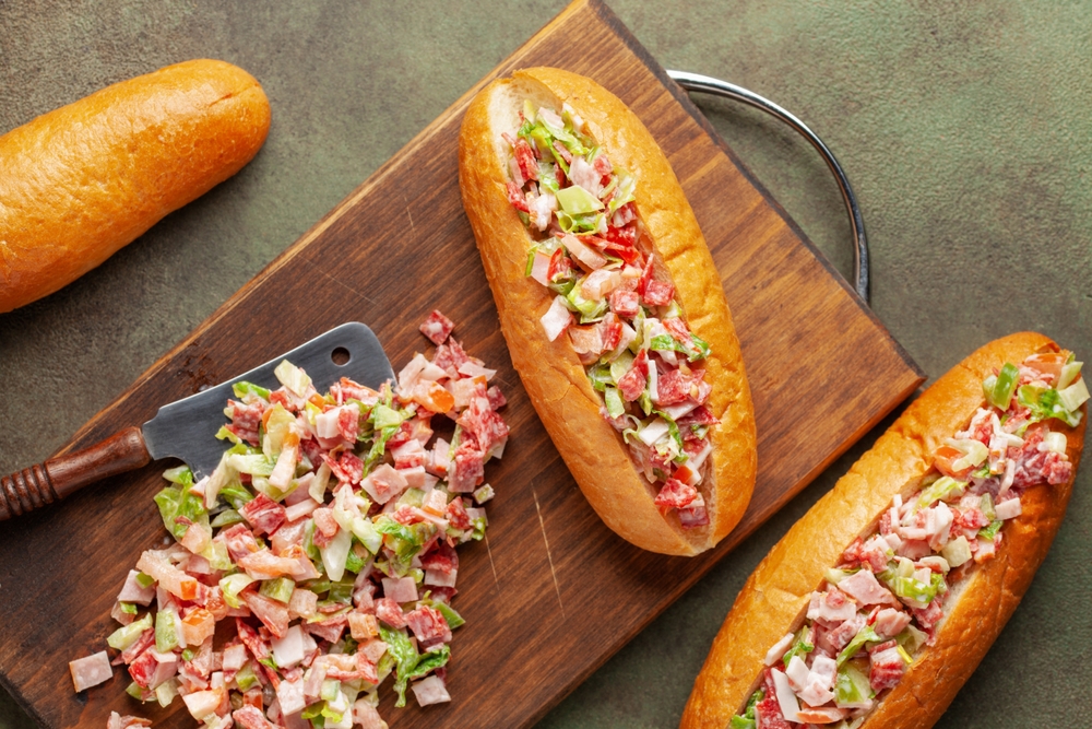 Chopped Italian sandwich.  Hot dog buns with lettuce,  sausages and vegetables. Trend food. Top view