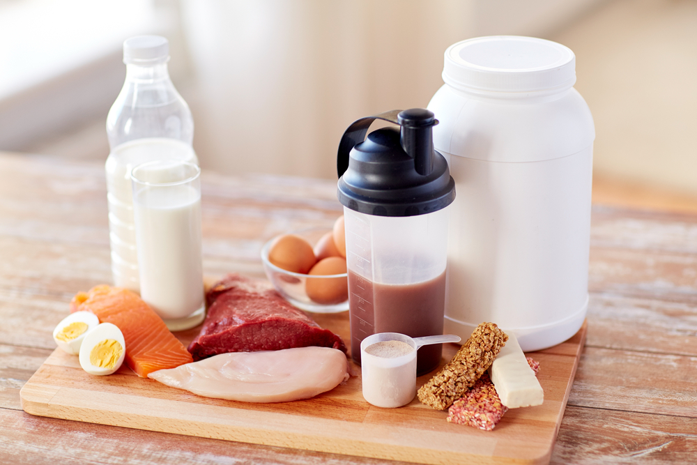 sport, fitness, healthy lifestyle, diet and people concept - close up of natural protein food and additive on wooden table