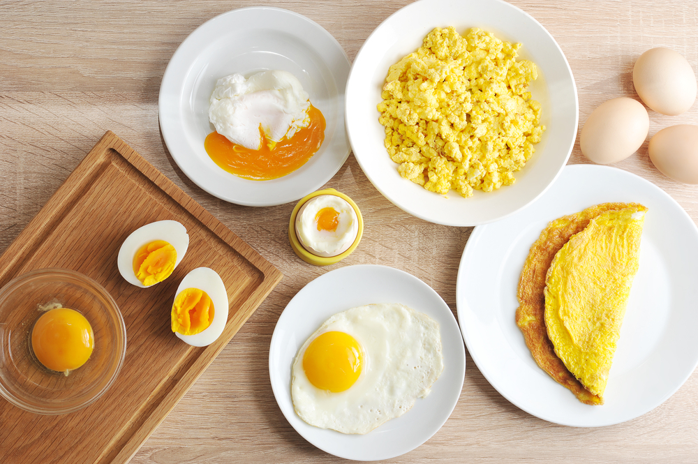Various ways of cooking chicken eggs. Omelette, poached, soft-boiled, hard-boiled, fried, scrambled eggs.  Top view. Close-up.