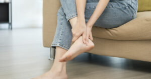 Podiatrists Warn: Don’t Ignore These 11 Signs From Your Feet woman holding her sore ankle