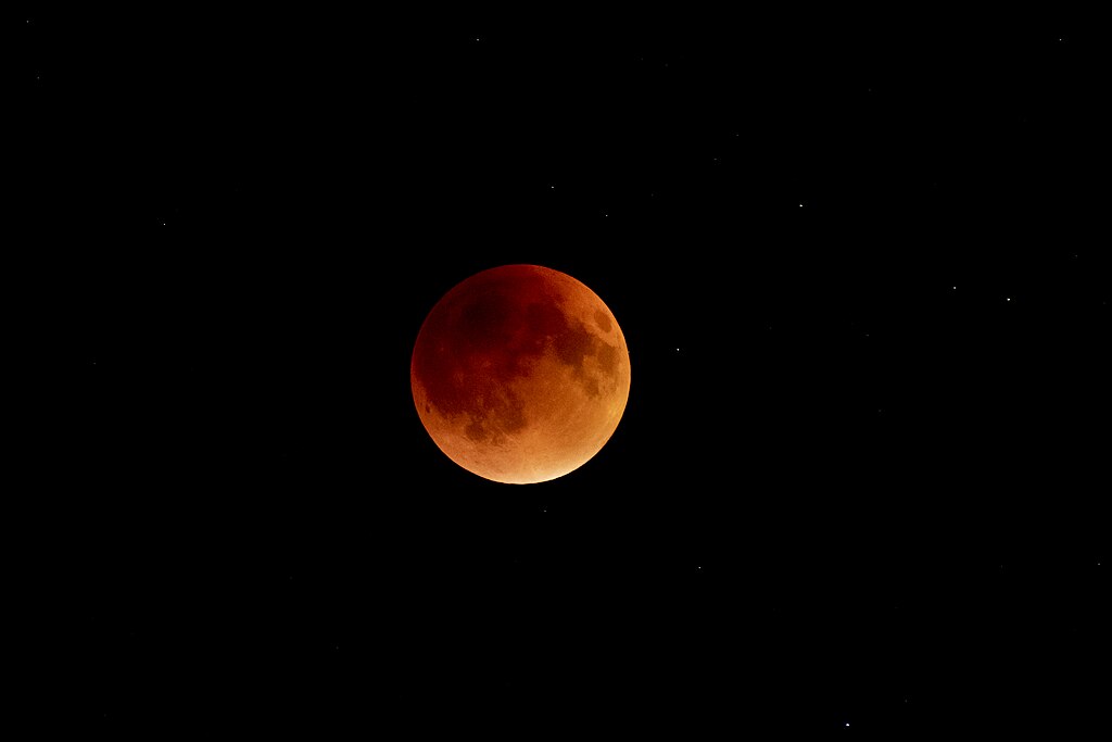Red-orange lunar eclipse against black night sky, the blood moon that appeared in September 2025 and sparked prophetic discussions