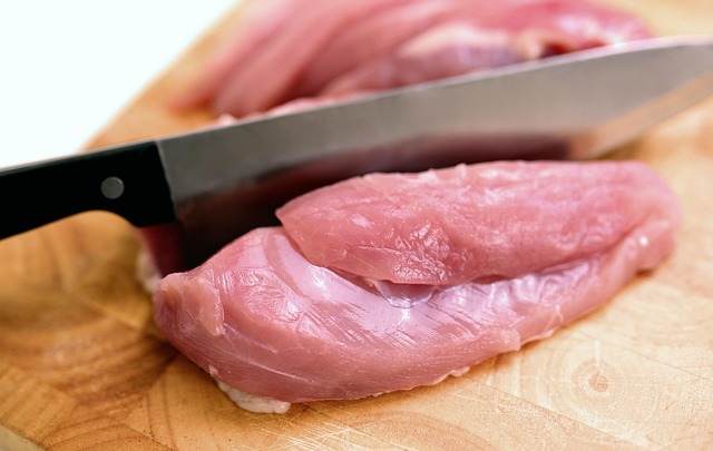 cutting raw chicken