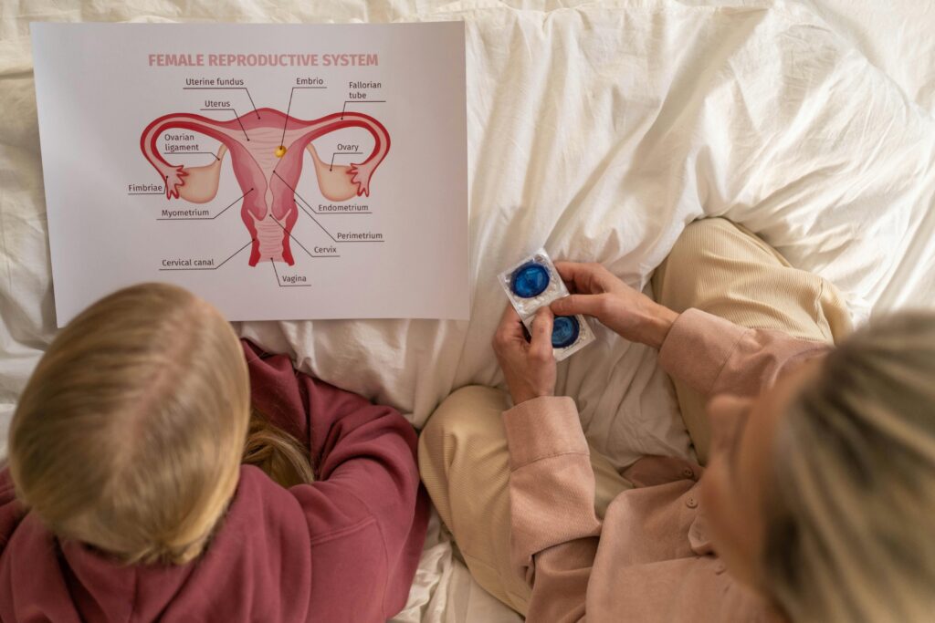 A Mother Holding Condoms while Looking at the Paper with Her Daughter
