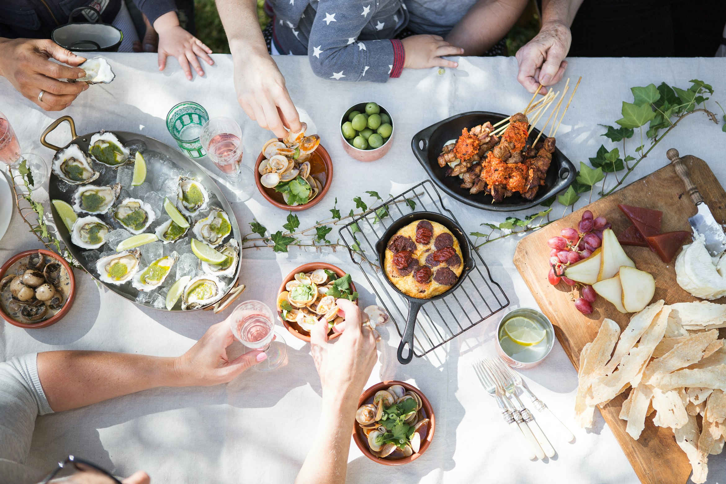 tapas, food, hands, a top-down shot of food, oysters, cheese, family eating