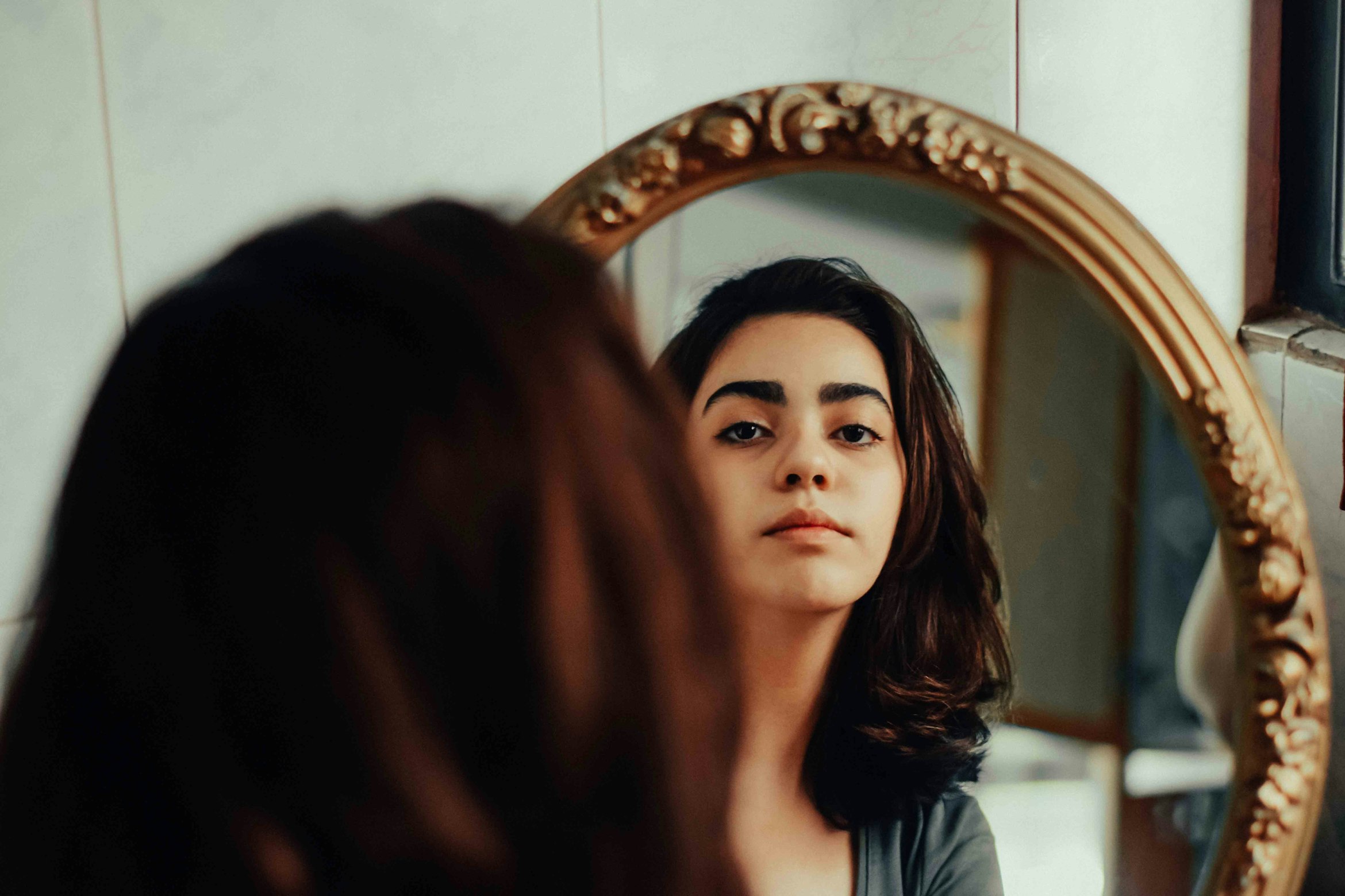 A woman looks in the mirror