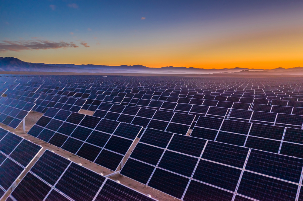 Aerial view of hundreds solar energy  panels rows along the dry lands at Atacama Desert, Chile. Huge Photovoltaic PV Plant in the middle of the desert from an aerial drone point of view during sunset