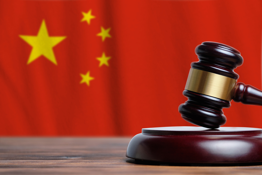 Justice and court concept in People Republic of China. Judge hammer on a flag background