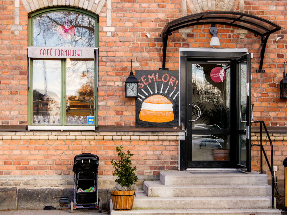 Nacka Sweden February 11 2017. Outside a coffee shop in Nacka. Brick building in a Stockholm suburb, Nacka. Typical Swedish pastry on a sign outside. Spring day in Scandinavia.