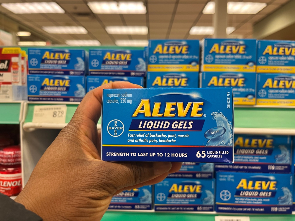 Edmonton, Canada - A Black person holding a box of Aleve Liquid Gels in a pharmacy