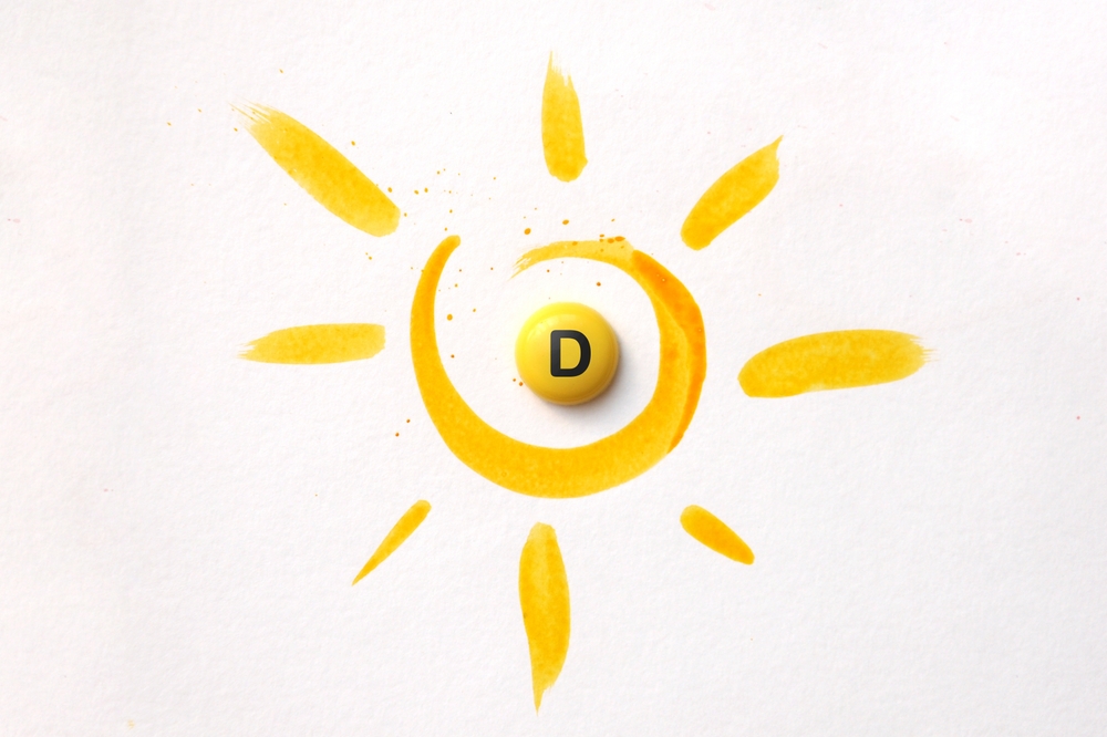 A tablet with the inscription Vitamin D in the center of the sun