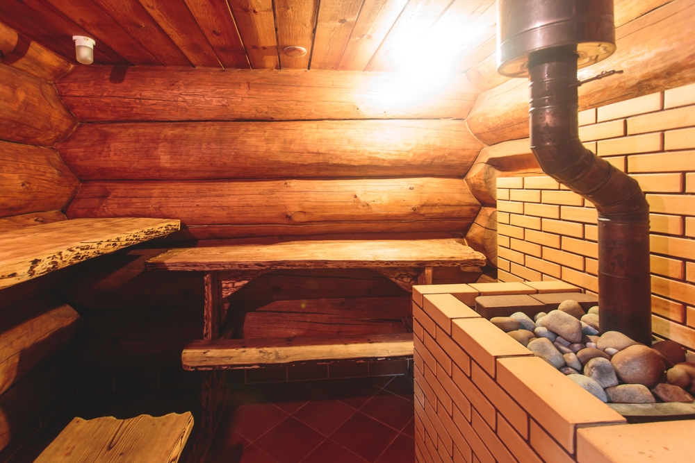 Traditional finnish sauna room wooden interior, cabin home wooden sauna spa cabin steam room with stone heater and wooden bench seats, relaxation and wellness in Scandinavia