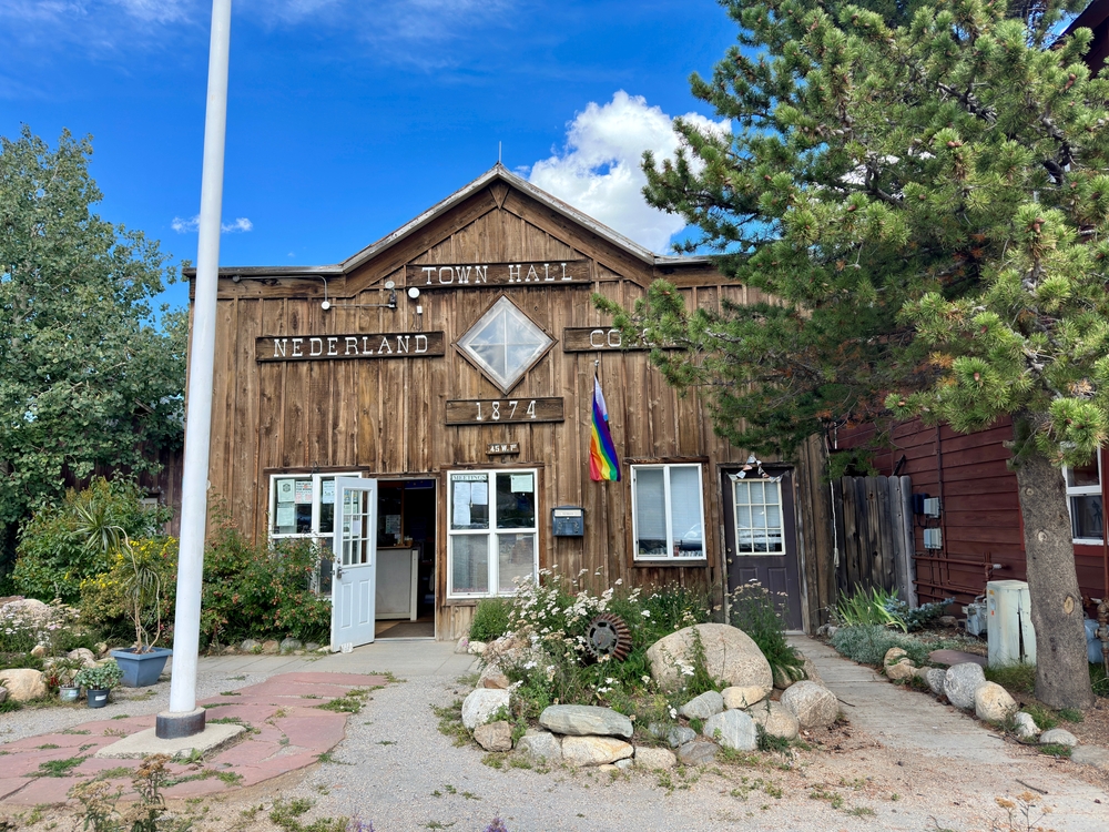 Nederland, Colorado, USA - September 20, 2023: Front of Nederland Town Hall with garden and flagpole. Local government and small town concept.
