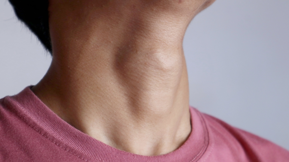 Photo of a man's Adam's apple and neck area protruding against on white background
