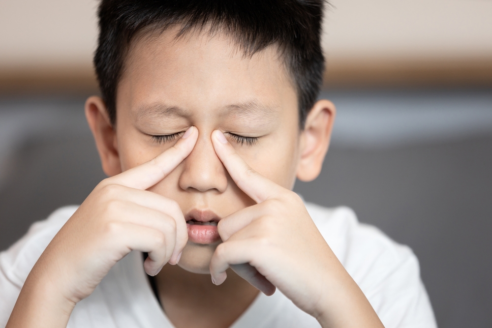 Child boy suffering chronic Rhinosinusitis,Rhinitis or acute Sinusitis,pain in nasal cavity,nose bridge sore,aching eye socket,sinus infections,nasal congestion,difficult to breathe through nostrils