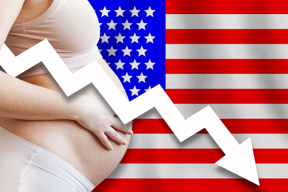 US Falling birth rates. Attractive pregnant woman belly against American flag background. Demographics and pregnancy in USA concept

