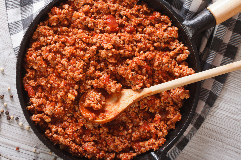 Bolognese sauce in a frying pan close-up on the table. horizontal view from above

