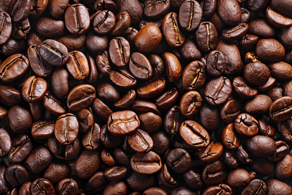 Photo of Big pile of fresh roasted coffee beans close up. Food photo for backdrops or recipes

