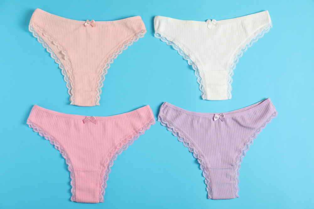 Women's underwear. Beautiful panties on light blue background, flat lay