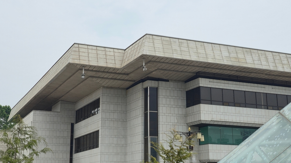 Civic architecture showcasing functional tiled massing with a hint of contemporary glass framework.