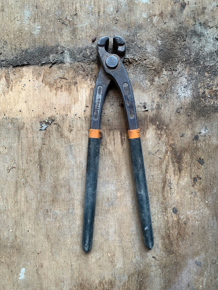 Top view of rugged vintage pliers on weathered wood. Sharp textures reflect labor, grit, and resilience. Great for industrial, repair, construction, workshop themes, etc.