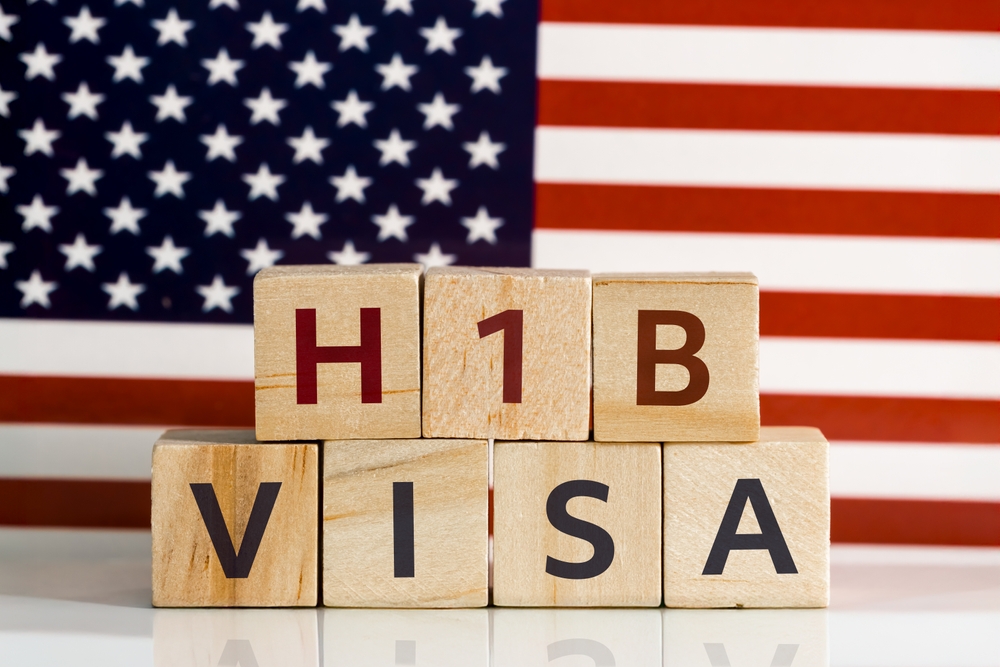 H1B text on wooden blocks against USA flag concept of Foreign Skilled Worker Visa concept. Close up view
