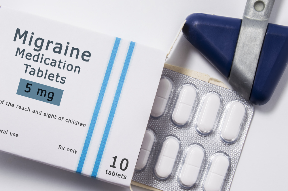Anti migraine drugs. Neurological Reflex Hammer and Packing Box of Medication with brand name mistriine by drug in blister with white back pills close by. The concept of migraine treatment
