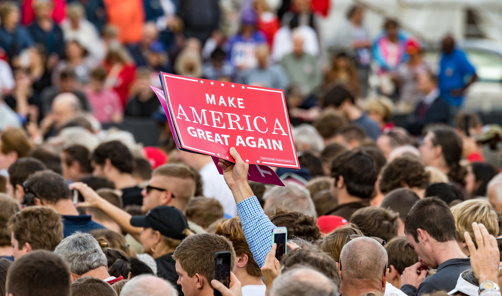 Mobile, Alabama - 12/17/2016: A Trump supporter holds up a "Make America Great Again" sign in the crowd as US President-elect Donald J. Trump prepares to enter the stage at Ladd-Peebles Stadium.