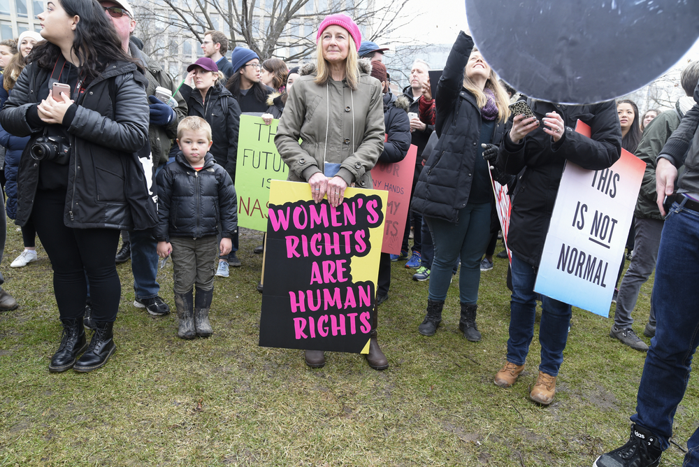 TORONTO-JANUARY 21:An old woman with sign, equaling  women's rights as human rights during the "Women's March on Washington" to protest against Trump presidency on January 21, 2017 in Toronto, Canada.