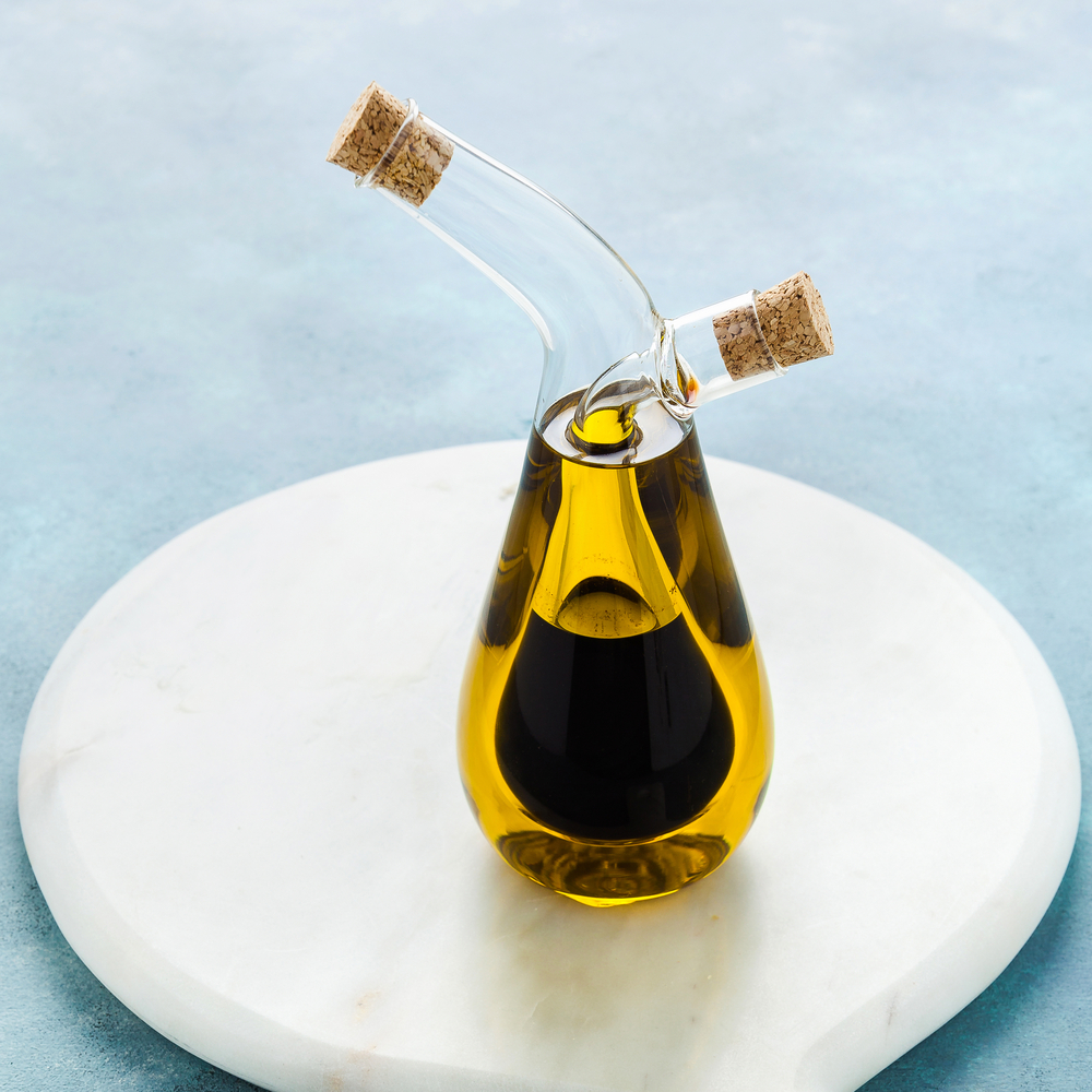 cruet with olive oil and balsamic vinegar on a blue board