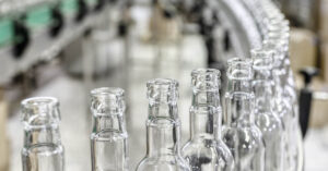 Line of glass bottles in factory/manufacturing setting