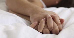 hands clasped together during intimacy