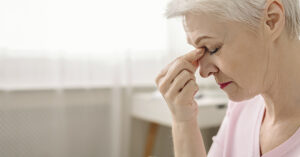 4 Things Women Need to Know About Hormones and Dementia Risk woman pinching bridge of nose