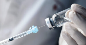Idaho Ends Vaccine Mandates, Sparking Push to Replicate the Law Nationwide needle extracting liquid from a clear vile. Vaccine and vaccination concept