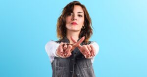 15 Assertive Yet Respectful Phrases to Handle Rudeness with Grace Sky blue background, with woman giving NO gesture