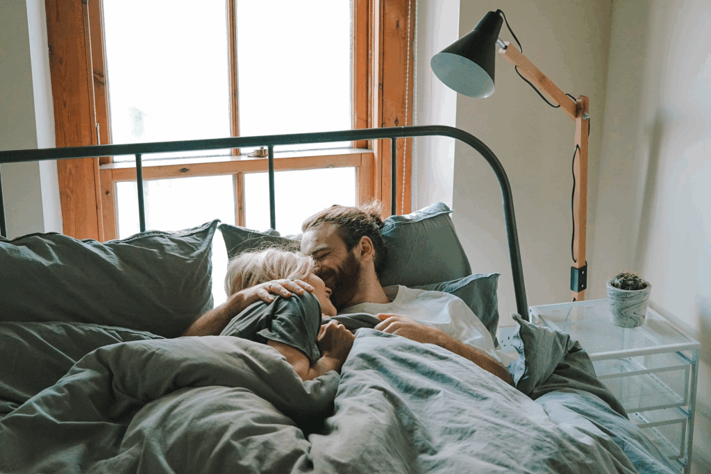 couple in t-shirts laughing in bed