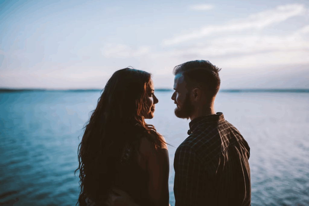 couple standing together in front of body of water