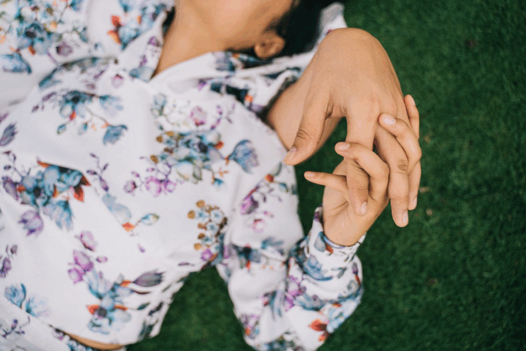 Couple in Floral Shirts Holding Hands on Green Grass